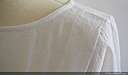 Blouse/chemisier droit à manches 3/4 en voile de coton blanc à plumetis. Devant croisé, dos droit, coupe cropped zoomé sur l’épaule,