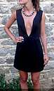 Robe en néoprène noir, corsage ajusté, sans manches, encolure en V très profonde, jupe trapèze. Taille 34, création sur mesure